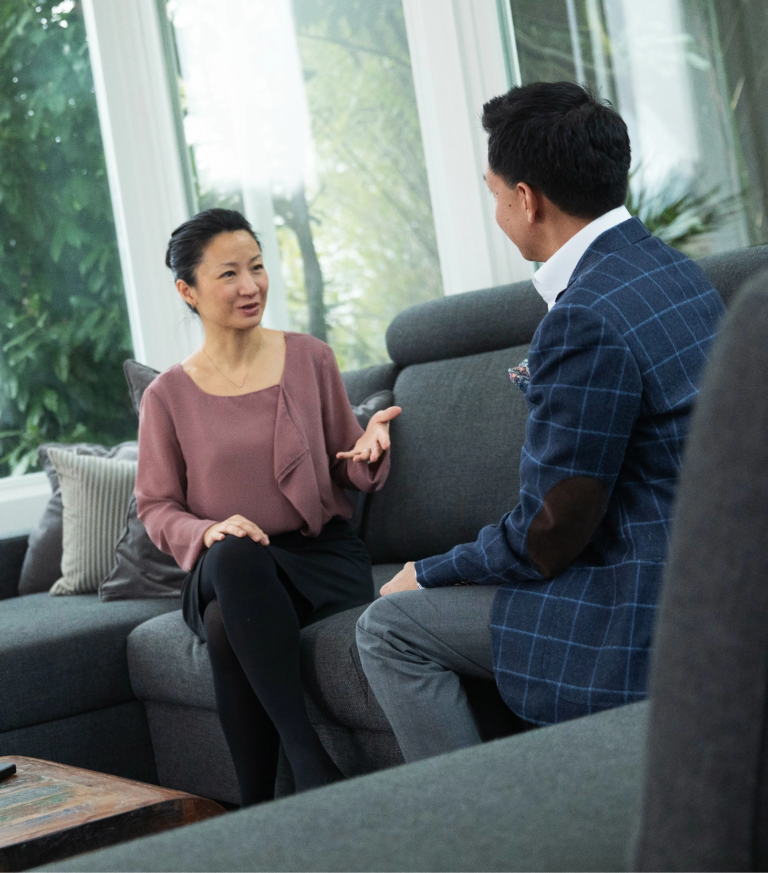 Woman and man in conversation on a gray couch